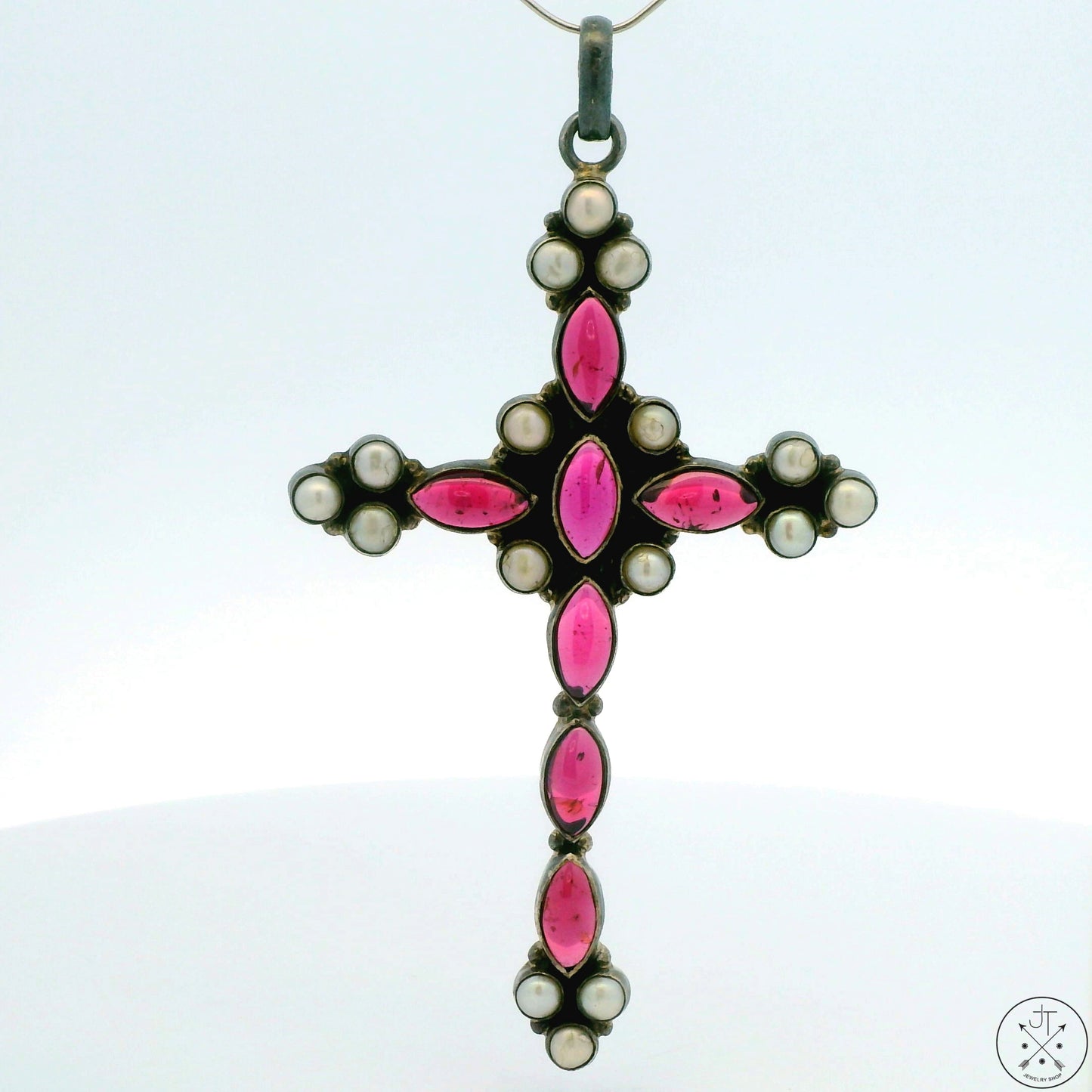 A vintage sterling silver cross pendant with rhodolite garnet and pearl detailing.