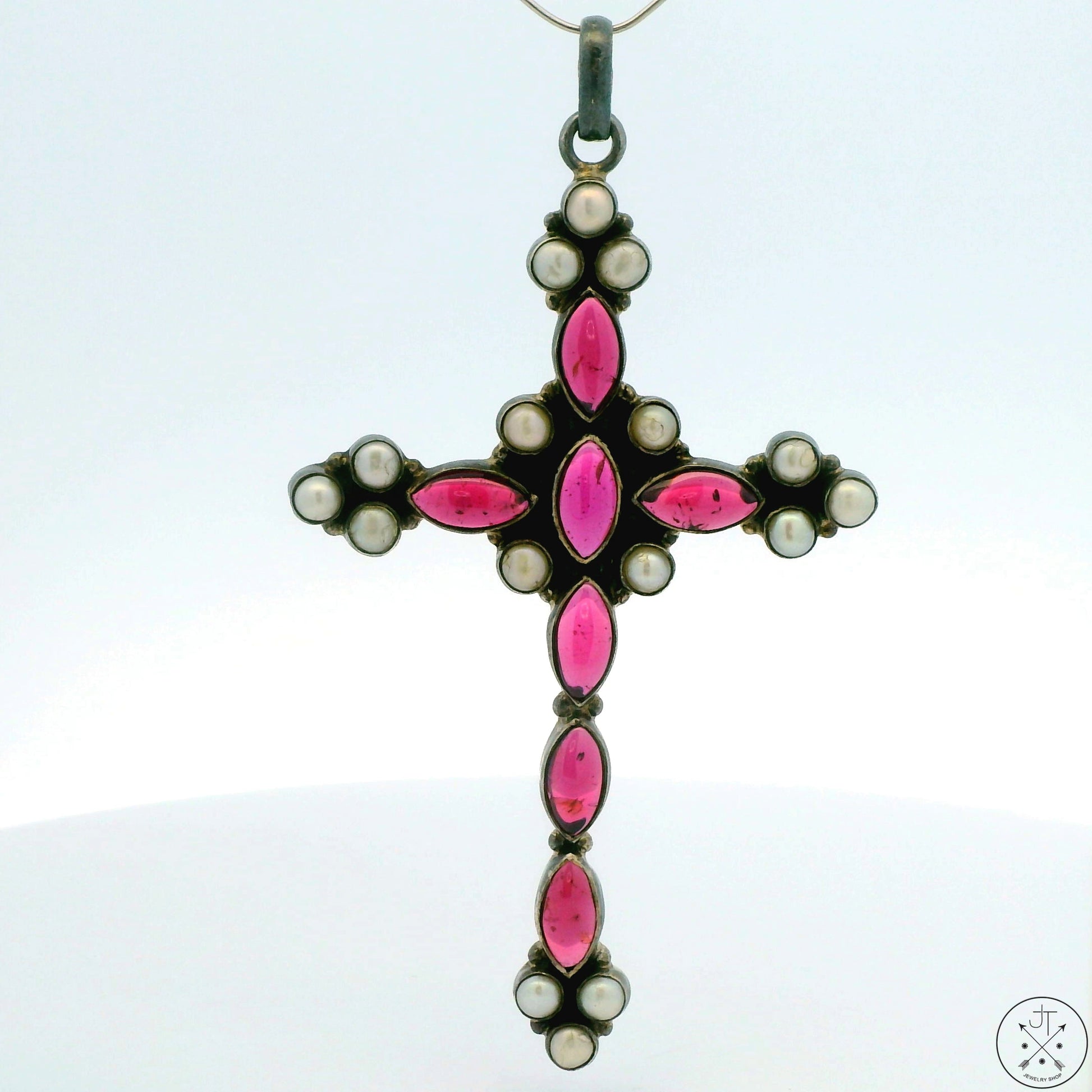 A vintage sterling silver cross pendant with rhodolite garnet and pearl detailing.