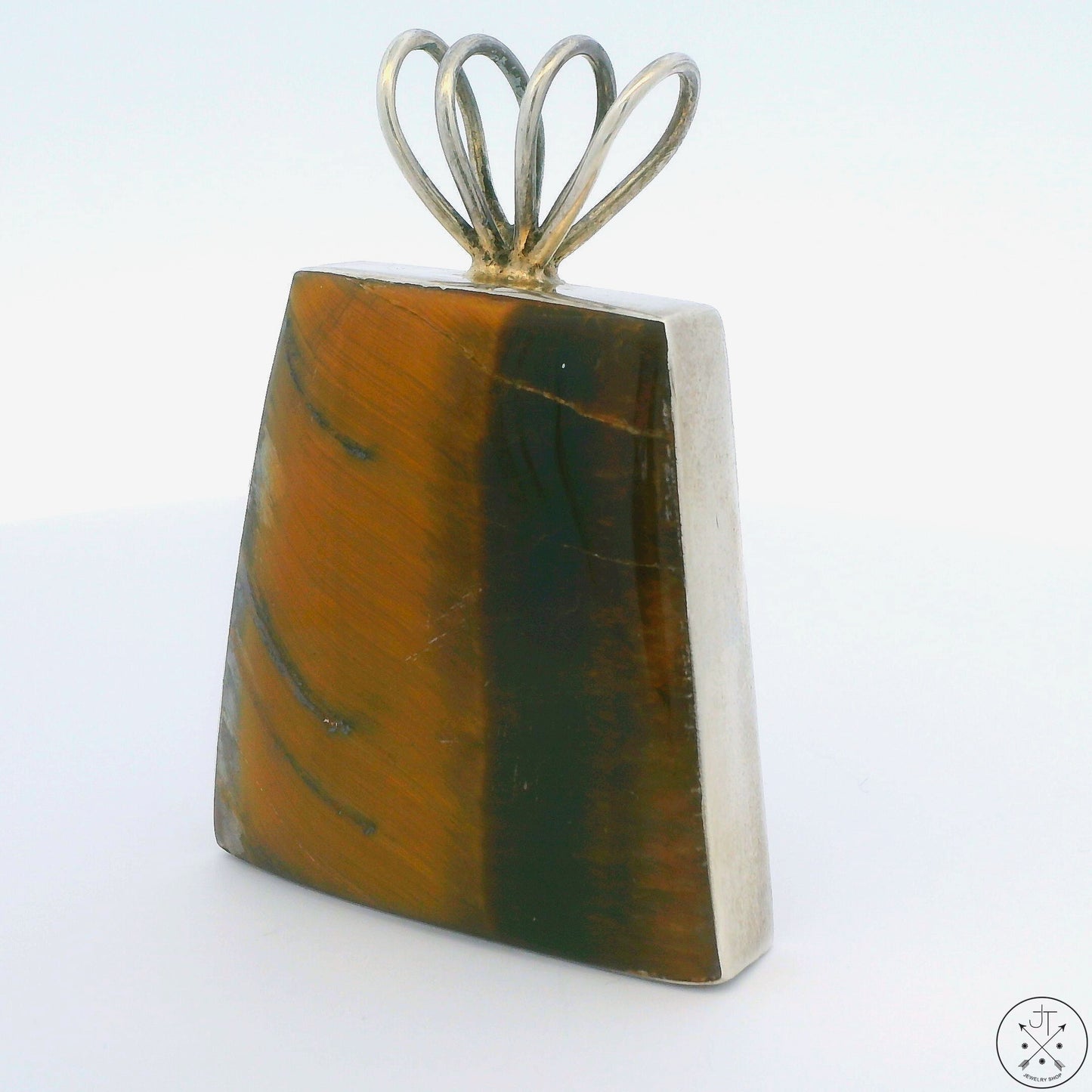 A sterling silver pendant with a tiger's eye gemstone set in a geometric frame, with a visible stamp mark reading 'mexico 925'.