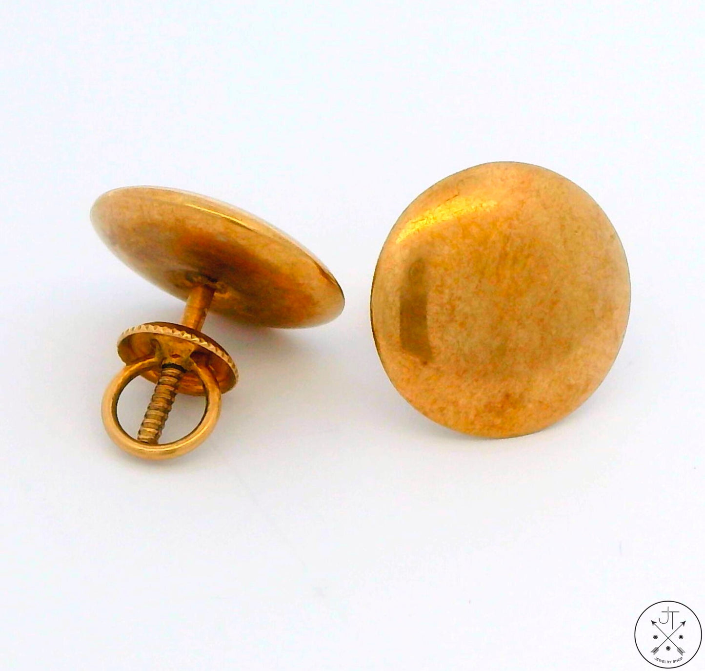 A pair of vintage 10k yellow gold stud earrings with a screw back closure, laying on a white surface.
