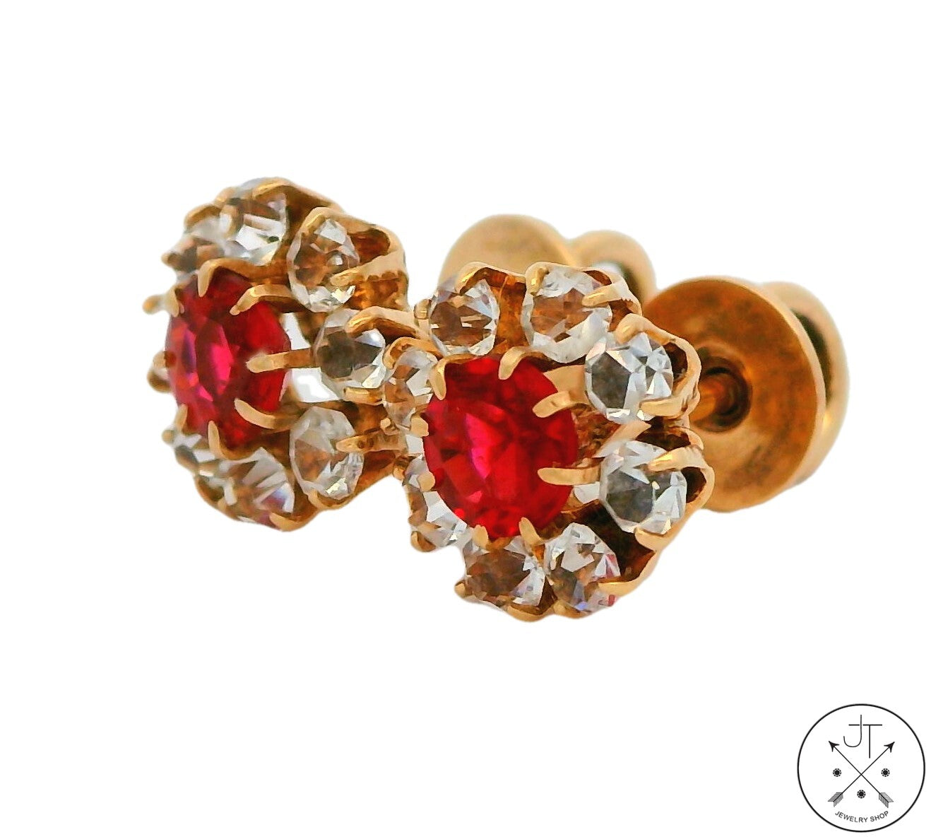 A pair of vintage 14k yellow gold stud earrings with red and white glass stones and metallic accents.