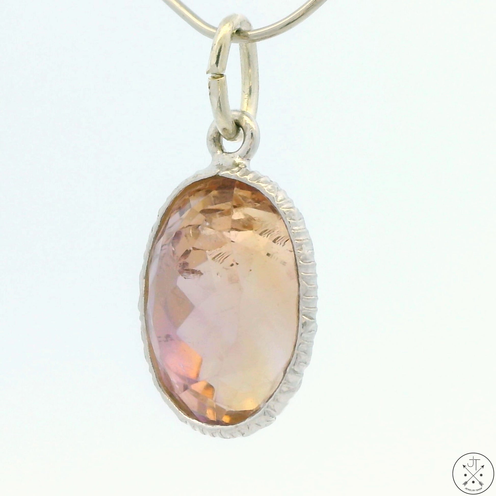 A sterling silver bezel set oval ametrine pendant.