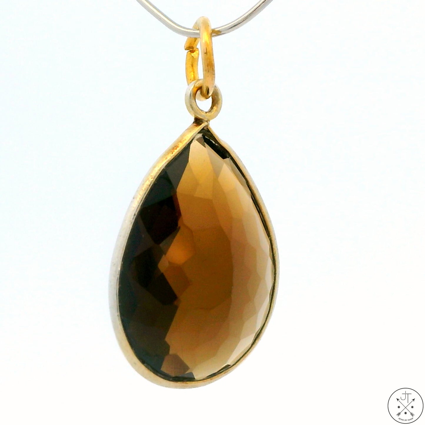 A gold-tone sterling silver bezel-set teardrop-shaped smoky quartz pendant.