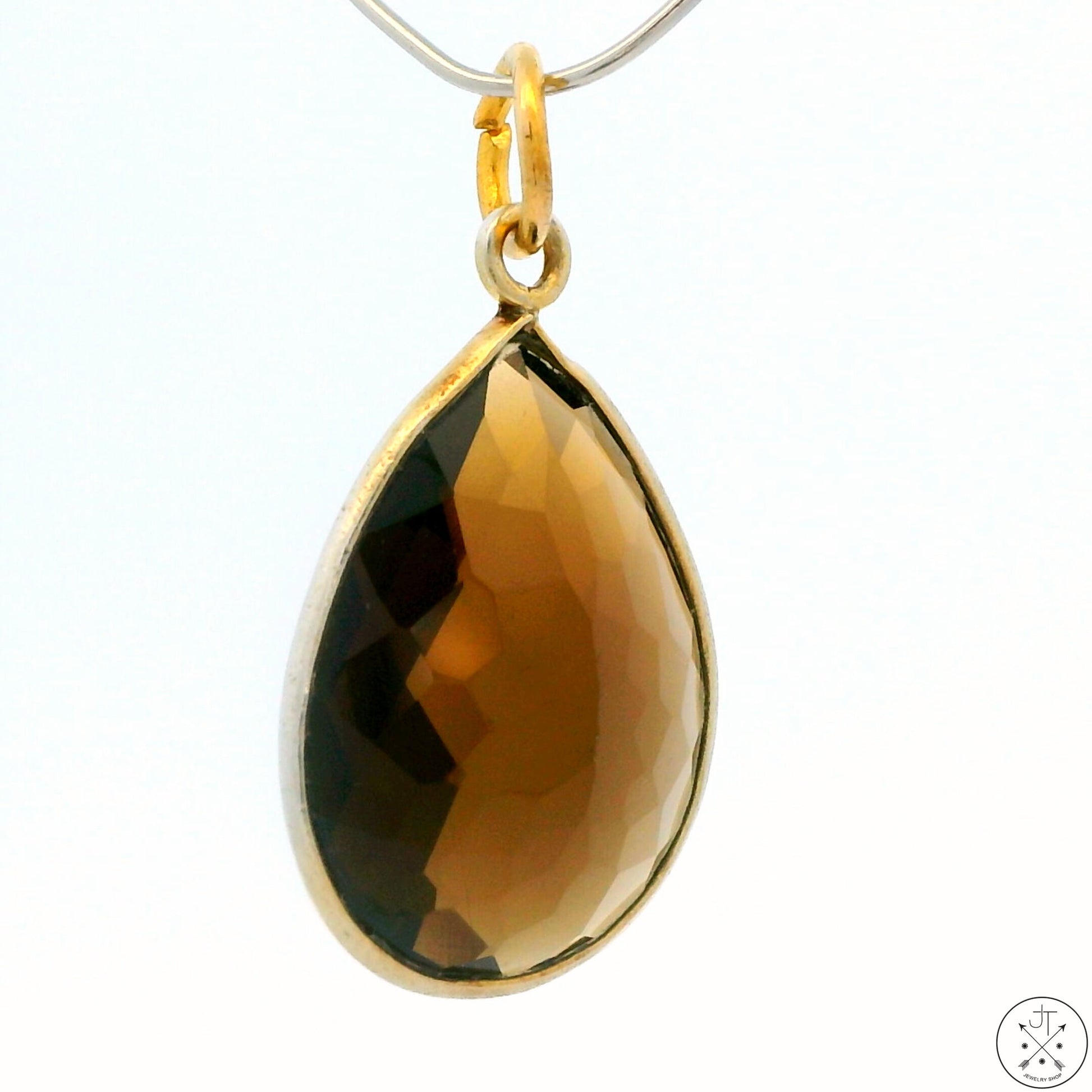 A gold-tone sterling silver bezel-set teardrop-shaped smoky quartz pendant.