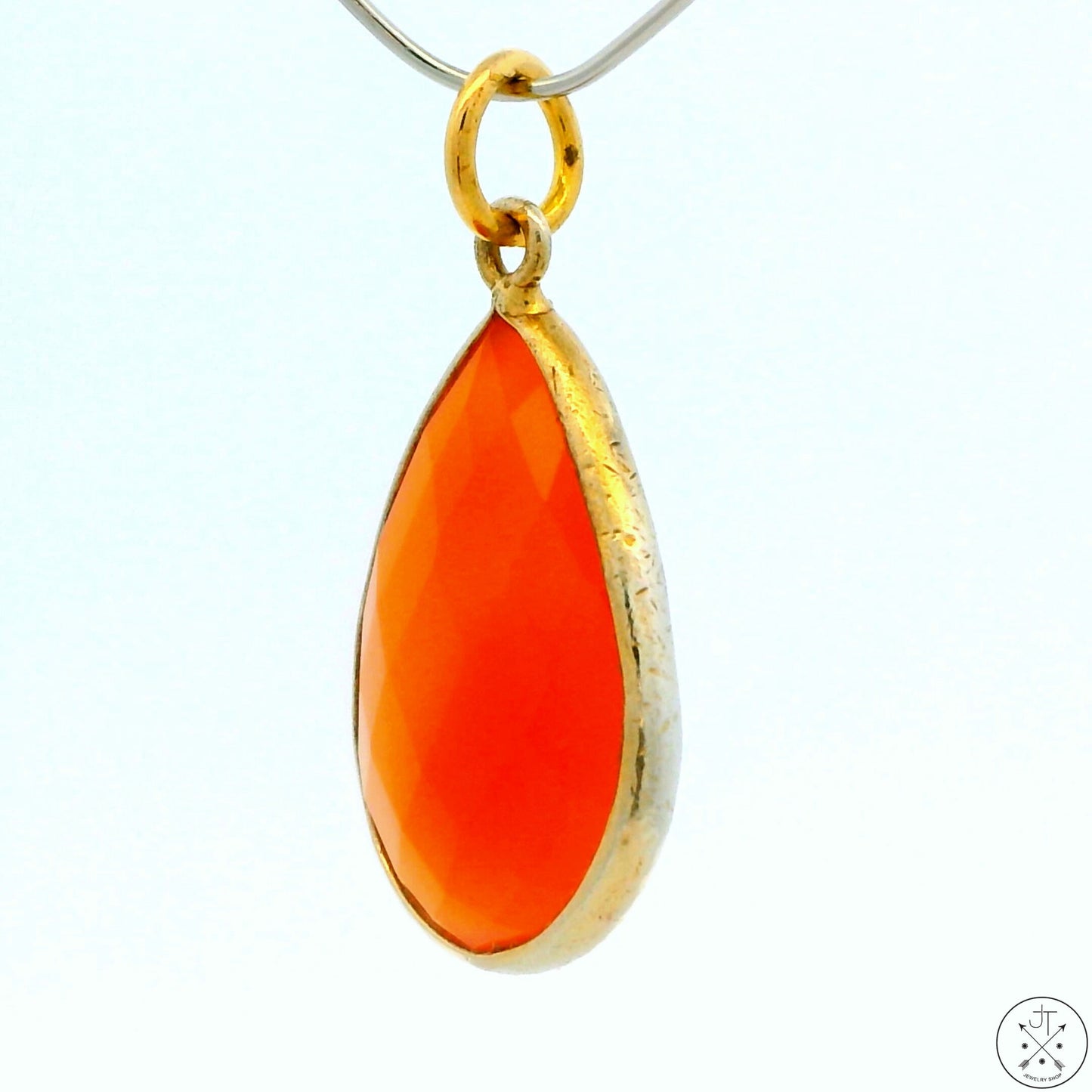 A gold-tone sterling silver bezel-set teardrop carnelian agate pendant.
