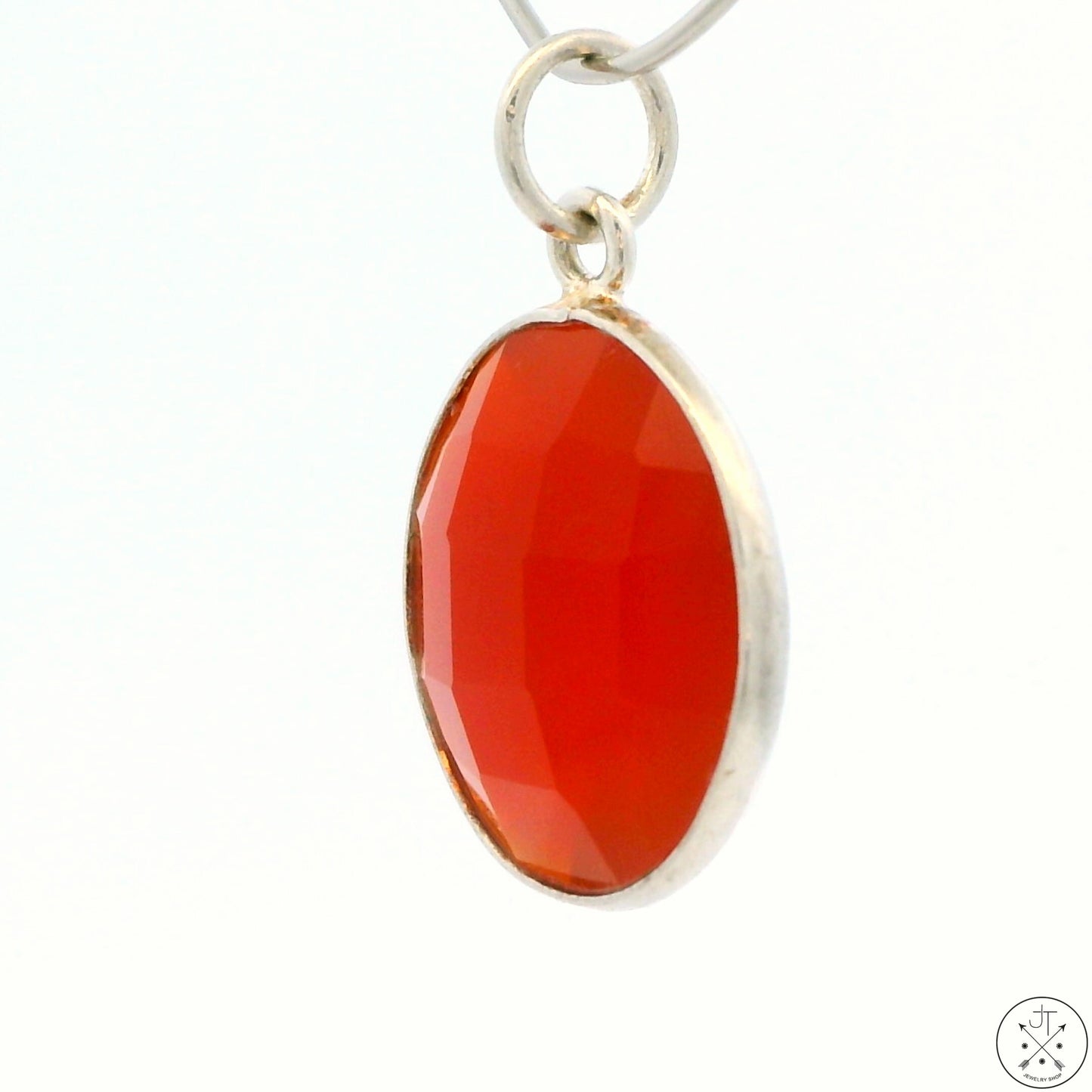 A sterling silver bezel-set carnelian agate pendant with a visible orange hue.