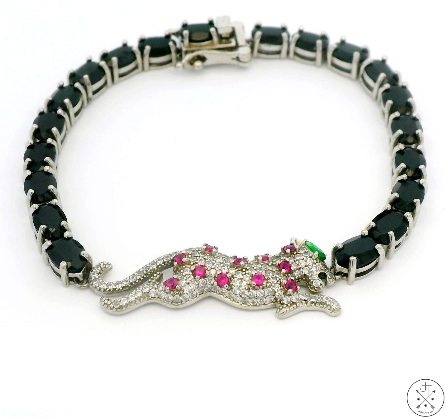 A sterling silver tennis bracelet with natural black spinel accents and a panther-shaped centerpiece adorned with pink and green spinel.