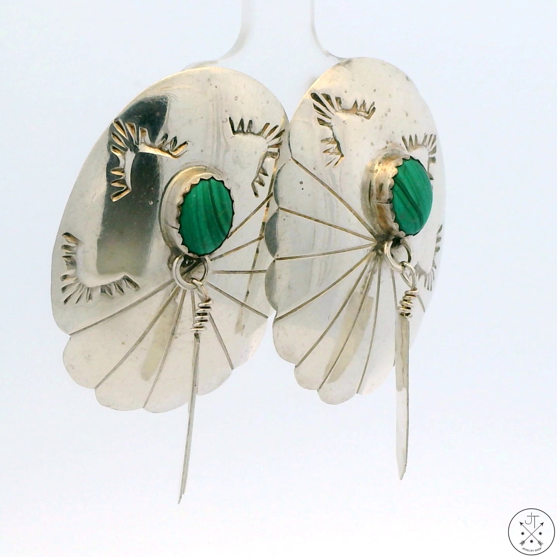 A pair of sterling silver drop earrings with turquoise accents and concho patterns, featuring a stud post design.