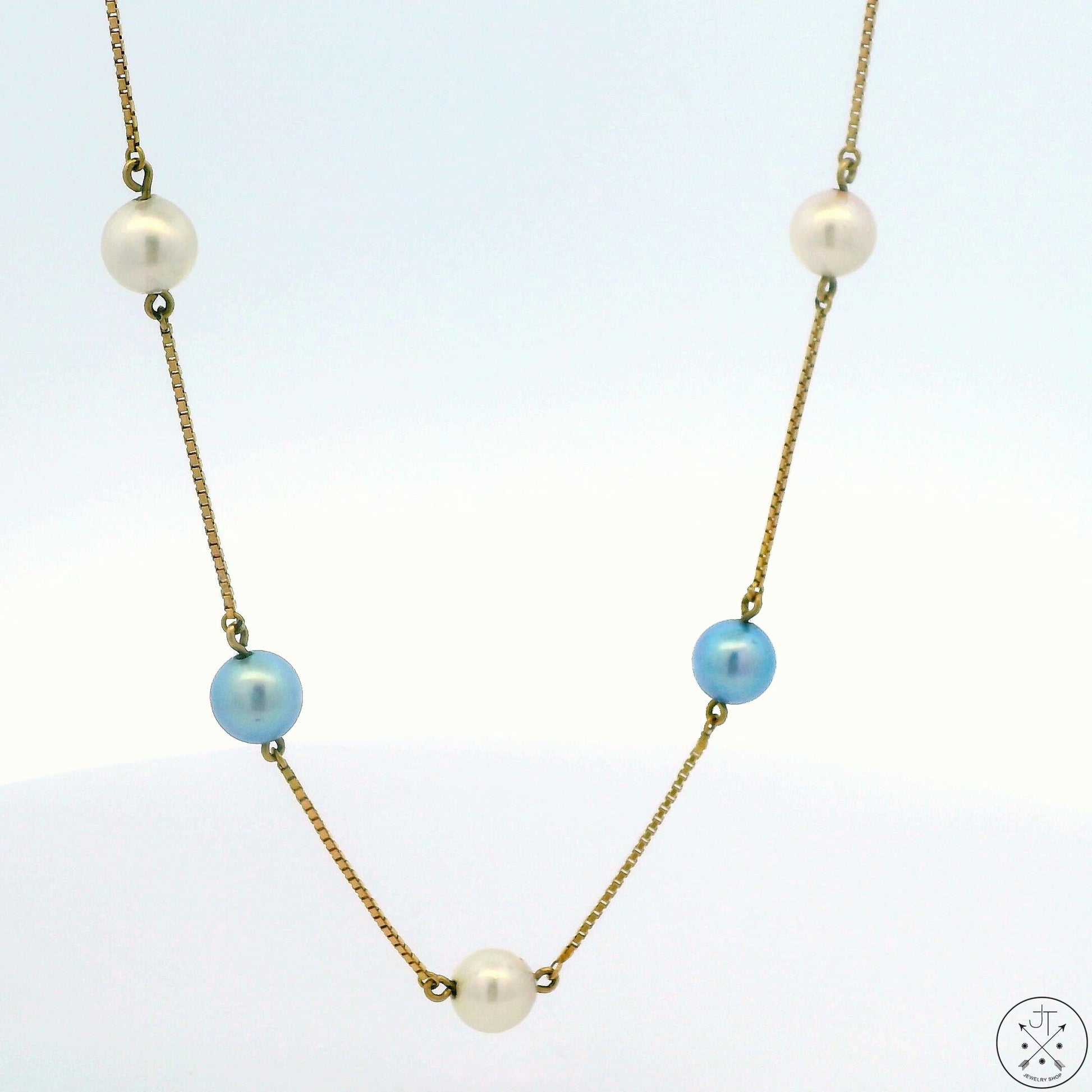 A vintage 18k yellow gold 30 inch pearl station necklace with a gold box chain and lustrous pearls.