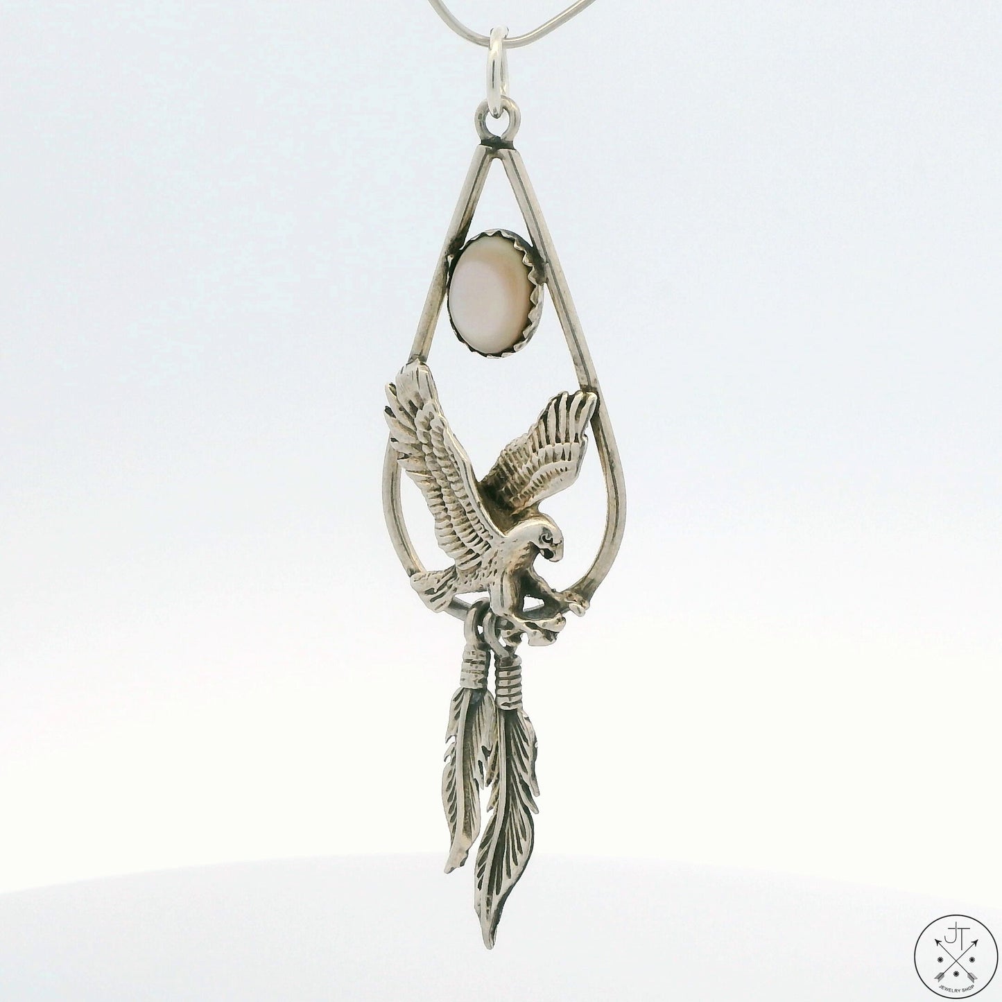 A sterling silver eagle feathers pendant with a mother of pearl inlay, with a split ring bale.