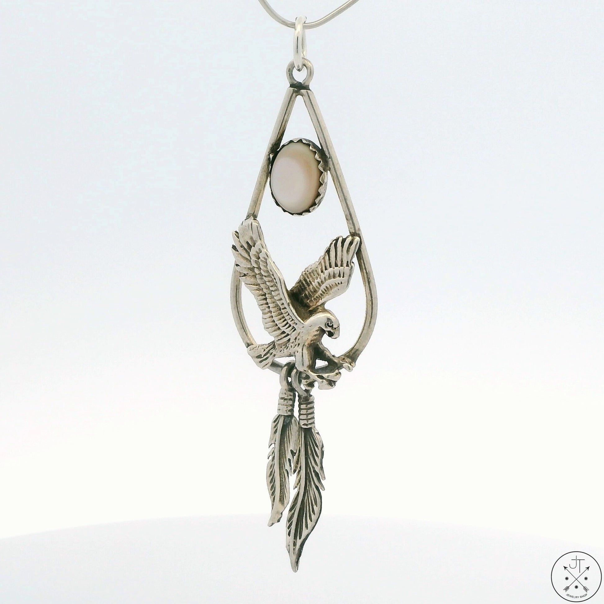 A sterling silver eagle feathers pendant with a mother of pearl inlay, with a split ring bale.