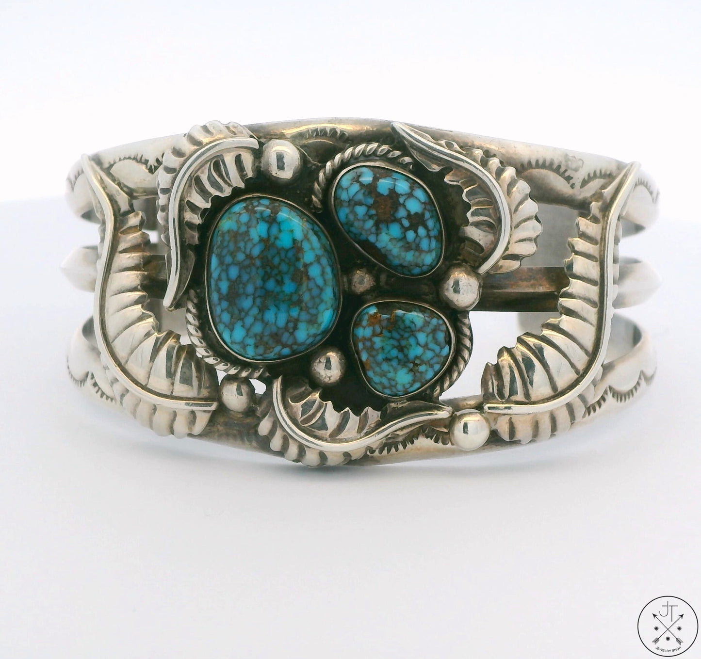 A vintage Navajo sterling silver cuff bracelet with three natural turquoise cabochons, signed by the artist.