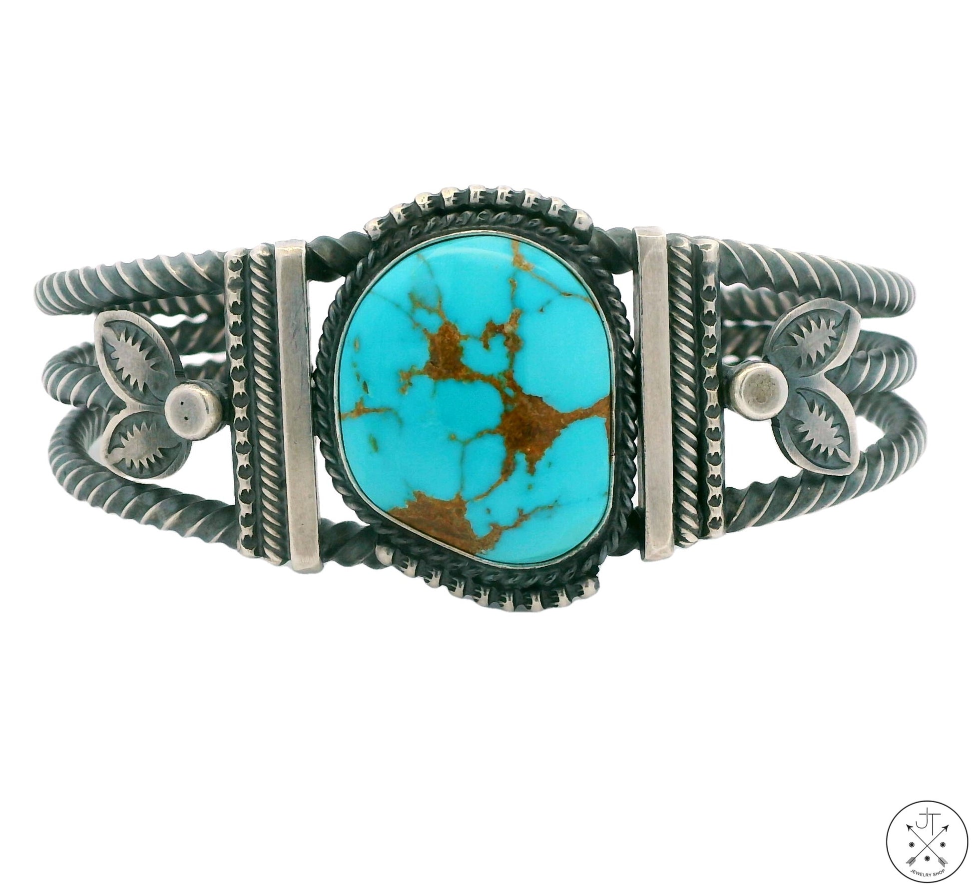 A Sterling Silver cuff bracelet with a Royal Blue Turquoise centerpiece and twisted silver designs around it.