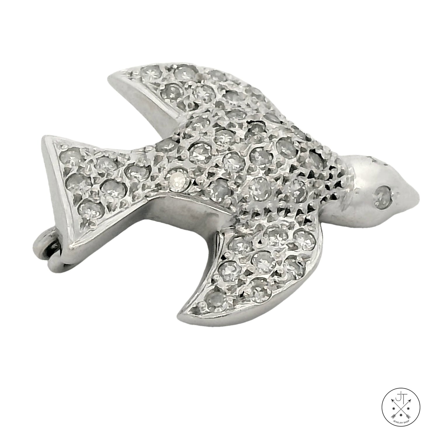 An 18k white gold brooch in the shape of a dove adorned with round faceted natural diamonds.