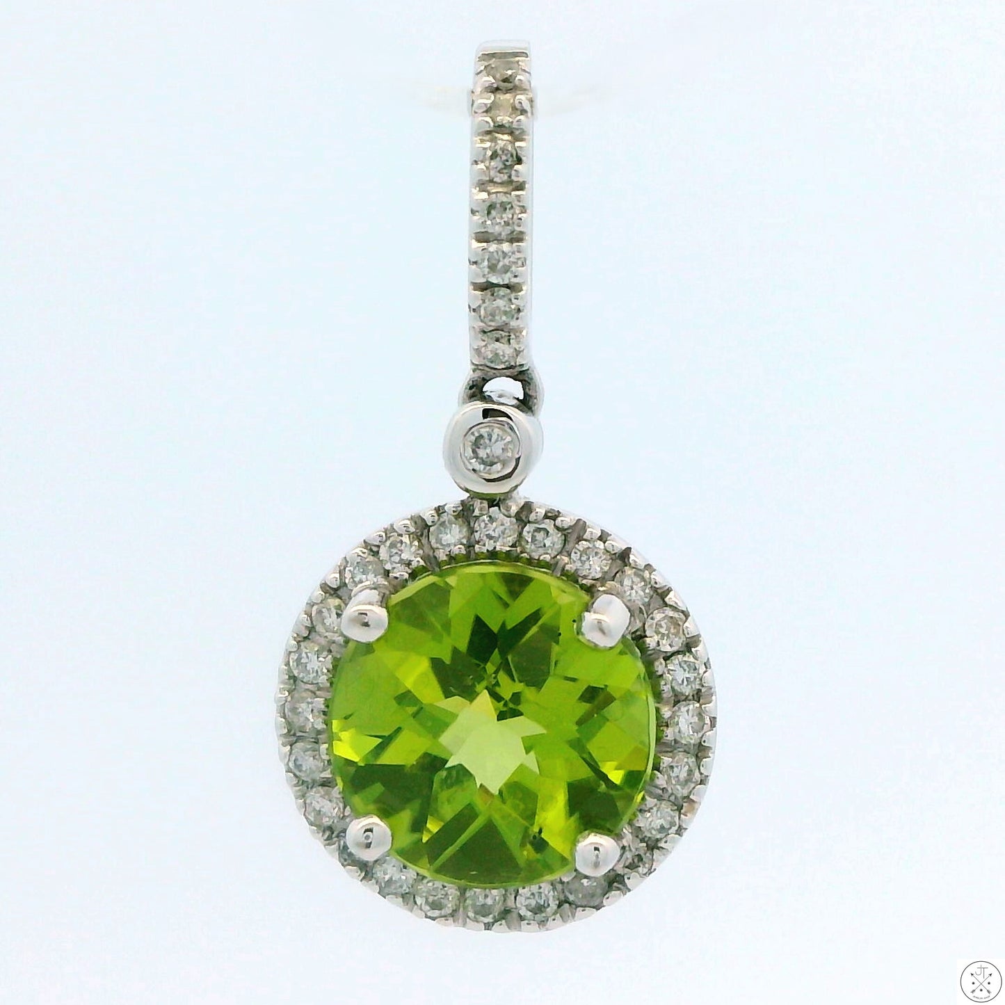 A 14k white gold pendant featuring a large green peridot gemstone with a halo of smaller diamonds around it, attached to a large bale.