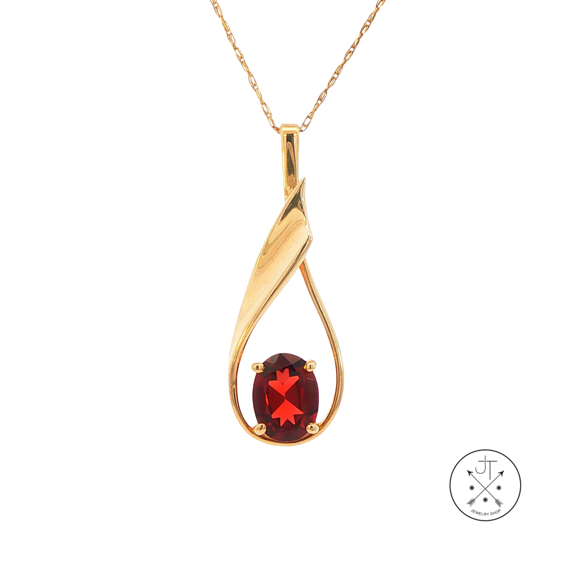 Gold pendant necklace with a red garnet gemstone on a white background