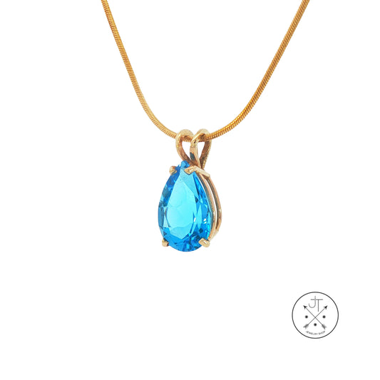 Gold necklace with a blue teardrop pendant on a white background