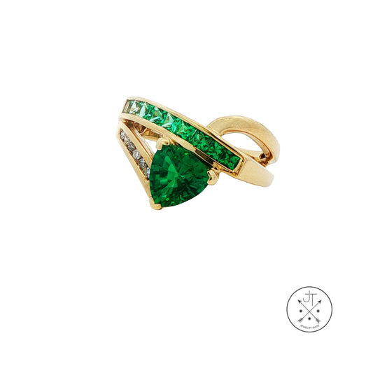 Gold ring with green gemstone on a white background