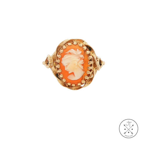 Gold ring with a cameo design on a white background