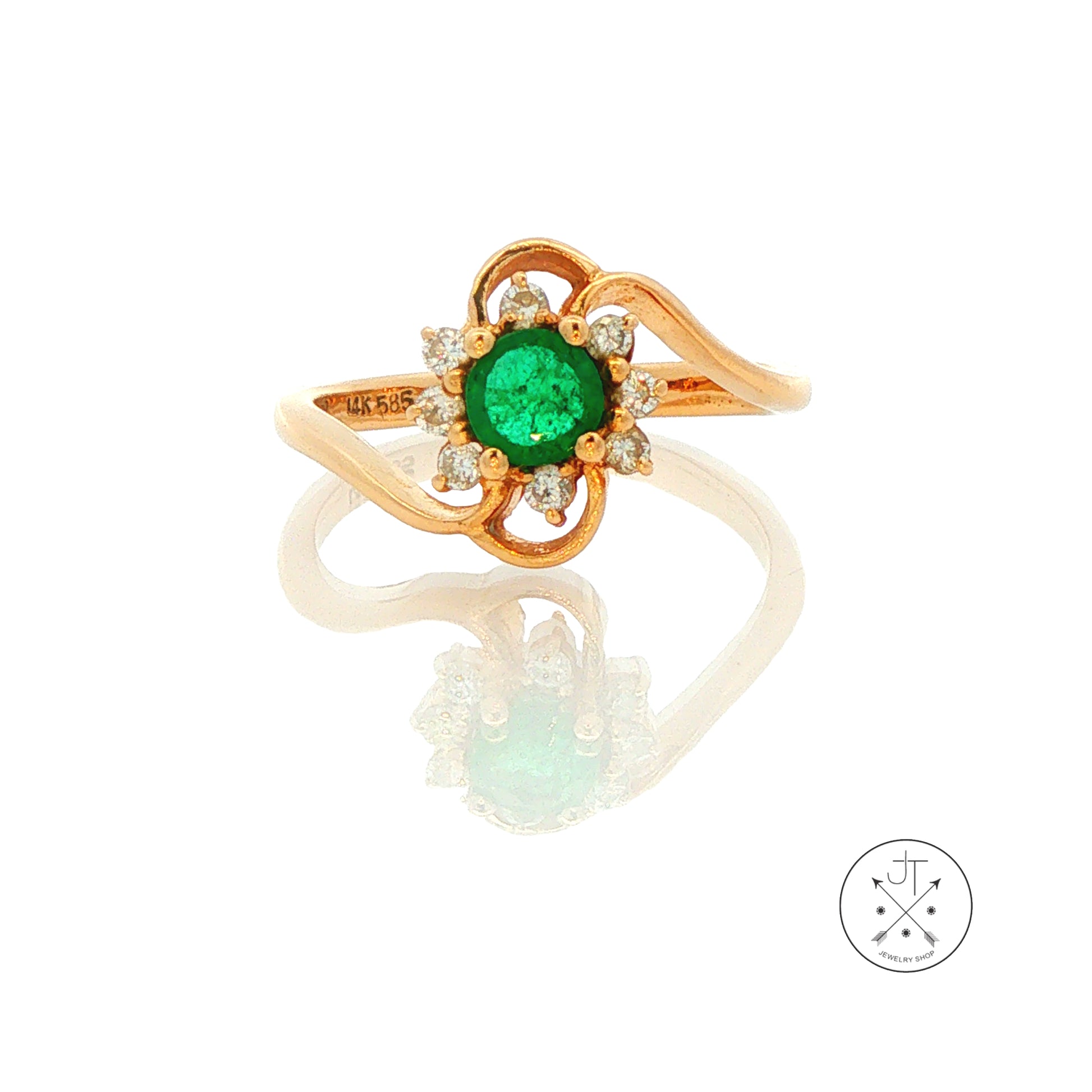 A yellow gold ring featuring a round green emerald center stone surrounded by small clear accent stones, set on a split wave-shaped gold band, shown on a white reflective surface.
