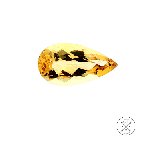 A faceted pear-cut golden Beryl, displayed on a clean white background with a small circular brand logo in the bottom right corner.