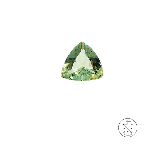 A single triangular faceted beryl gemstone with a light green and olive green coloration, shown on a plain white background with a small circular logo in the bottom right corner.