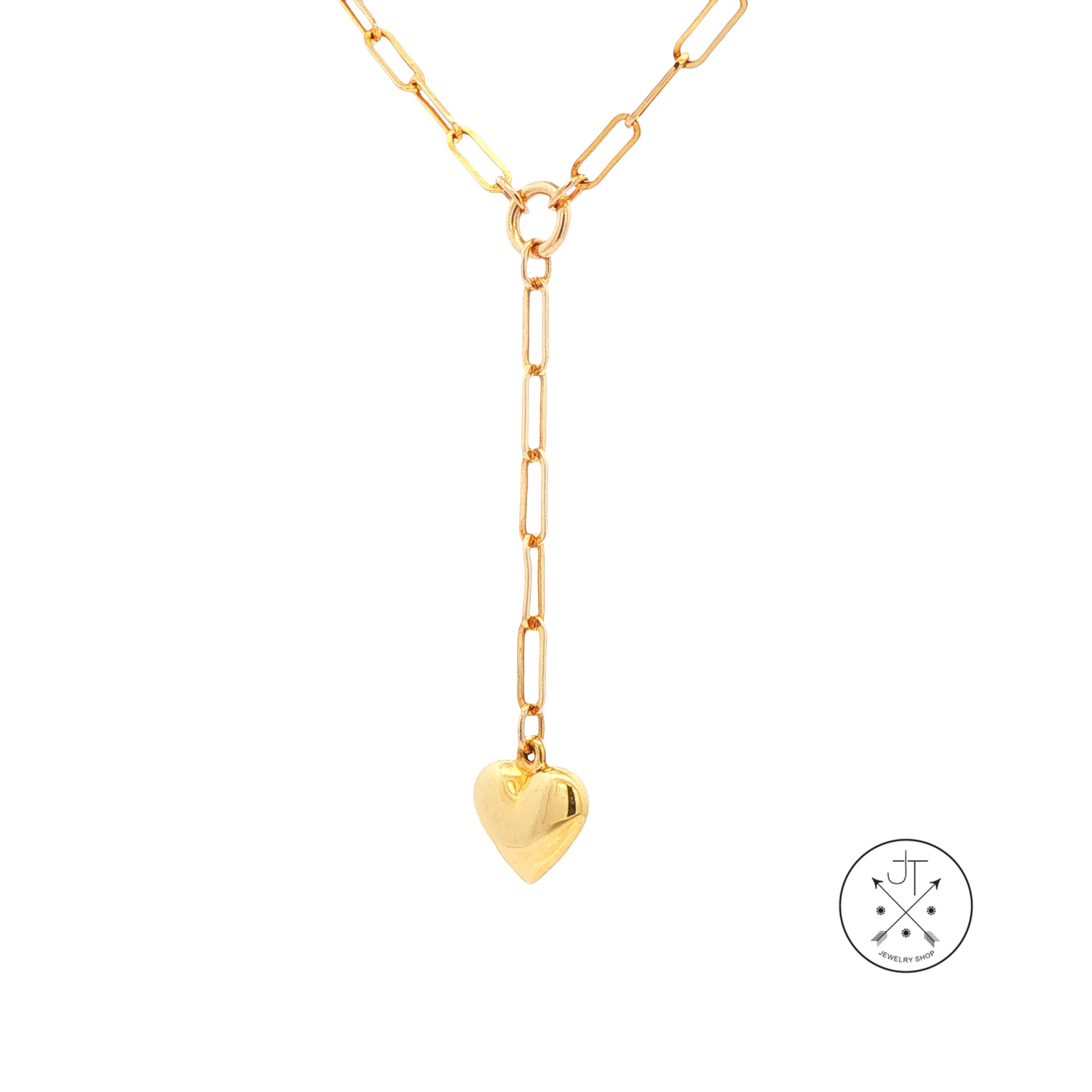 A gold paperclip chain necklace with a Y-shaped drop and a small heart pendant, shown on a plain white background with a circular brand logo in the bottom right corner.