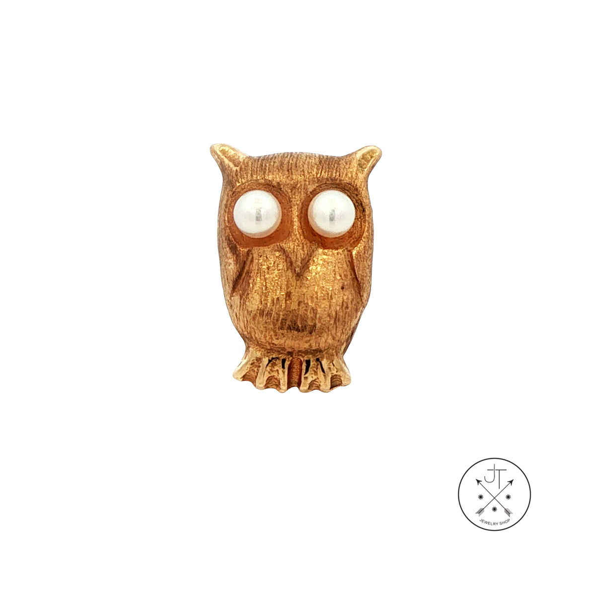 An owl-shaped gold lapel pin with natural pearl eyes, shown on a plain white background with a small circular brand logo in the bottom right corner.
