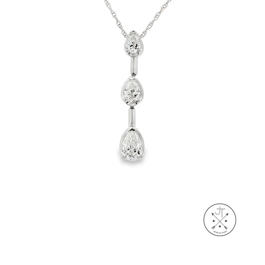 A white gold diamond necklace with a vertical dangle pendant featuring three pear-cut diamonds, shown on a plain white background with a circular brand logo in the bottom right corner.